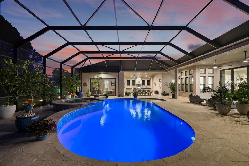 A screened-in patio features a blue swimming pool, a hot tub, and outdoor seating — 229 CONSERVATORY DRIVE, PALM COAST, FL