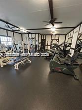 A home gym features exercise equipment, dark flooring, and white walls with dark wood trim — 3760 Inverrary Dr # 2R, Lauderhill FL 33319, LAUDERHILL, FL