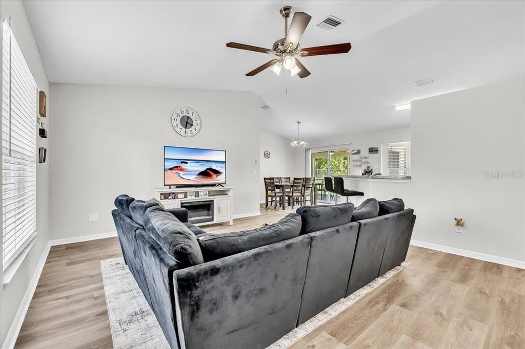 A living room features a large gray sectional sofa, a television, and wood-look flooring — 3776 JUNCTION STREET, NORTH PORT, FL