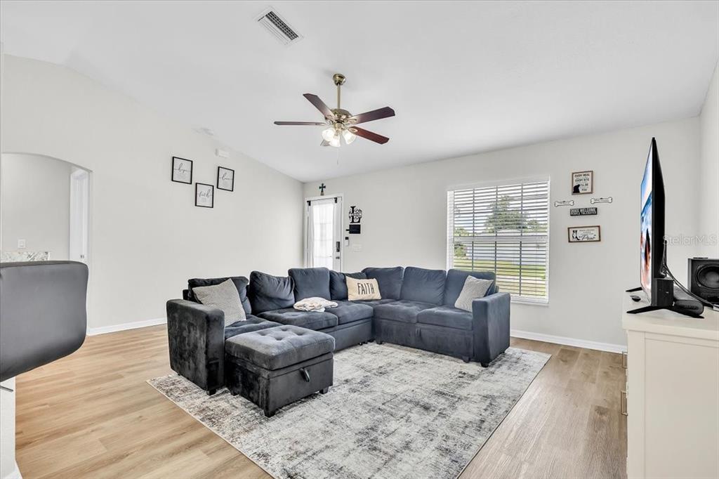 A living room features a dark sectional sofa, a gray area rug, and a ceiling fan — 3776 JUNCTION STREET, NORTH PORT, FL