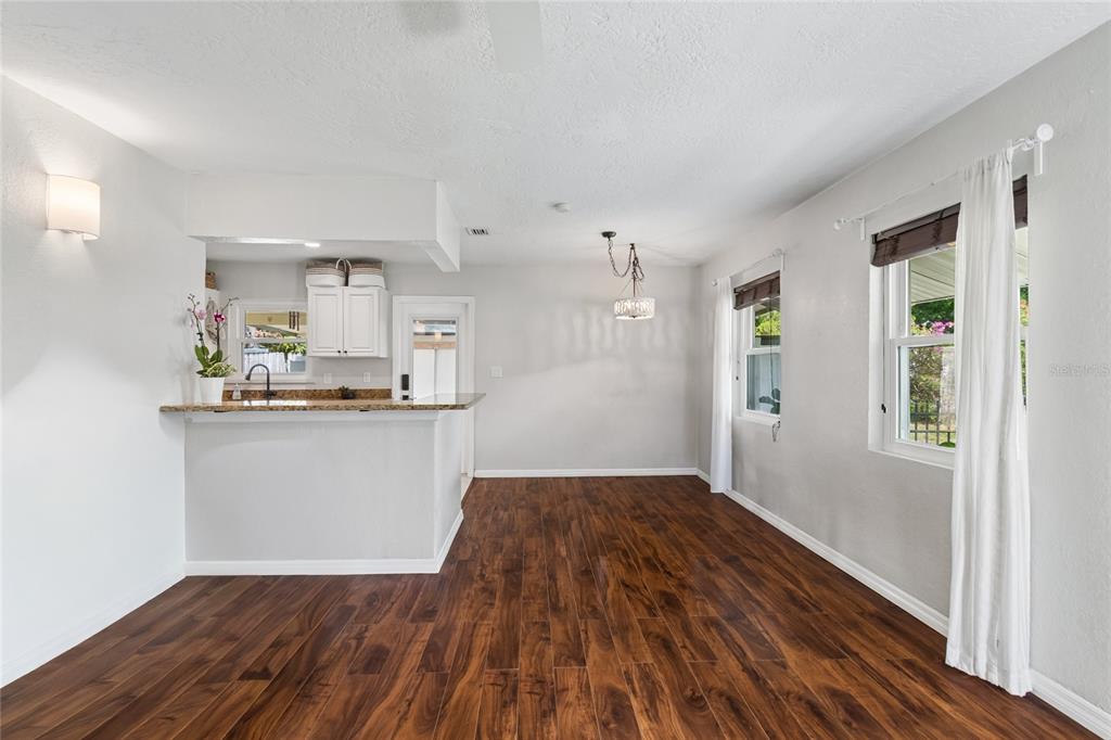 A dining area features dark wood flooring, a breakfast bar, and a hanging light fixture — 3912 W LEILA AVENUE, TAMPA, FL