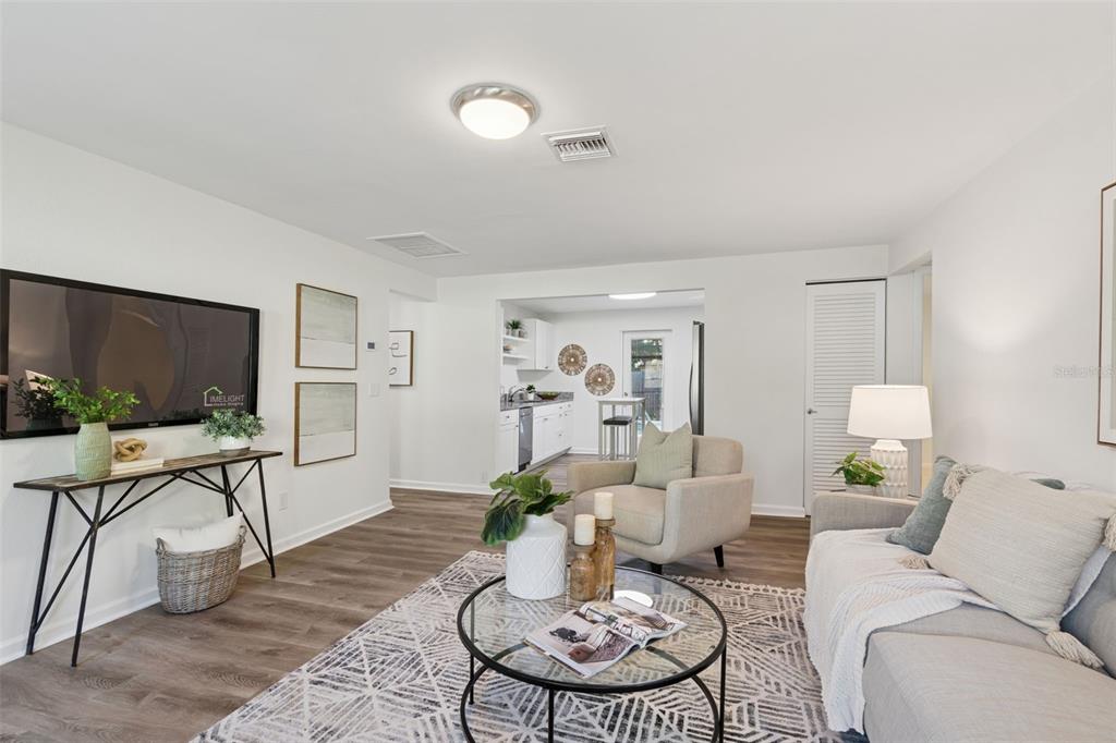A living room features a grey sofa, armchair, area rug, and a front door — 2195 GLEN DRIVE, SAFETY HARBOR, FL
