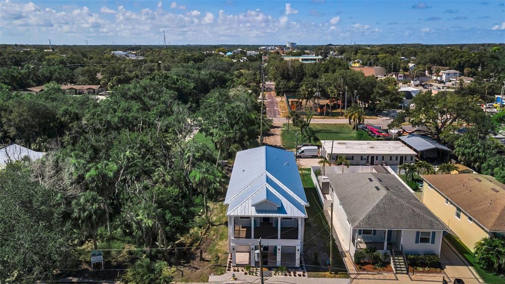 An aerial view shows a two-story house with a metal roof next to a street — 158 E SPRUCE STREET, TARPON SPRINGS, FL
