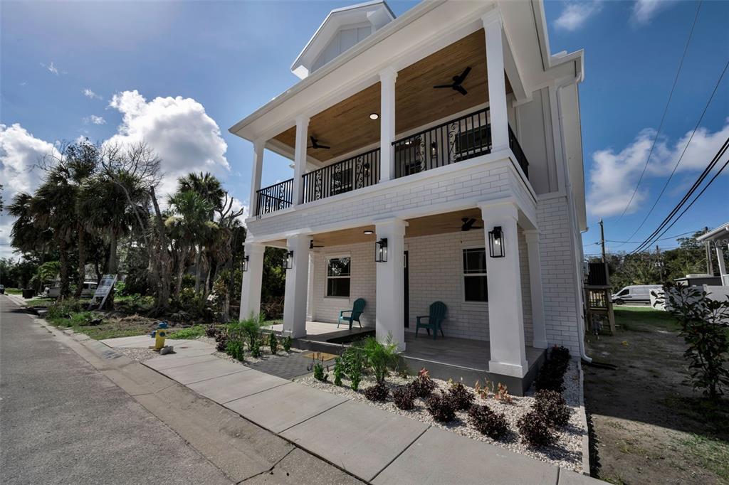 A two-story white house with a covered front porch and a second-floor balcony — 158 E SPRUCE STREET, TARPON SPRINGS, FL
