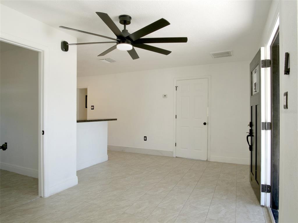 An interior view of a room with white walls, tile flooring, and a ceiling fan — 15201 BAILEY HILL ROAD, BROOKSVILLE, FL