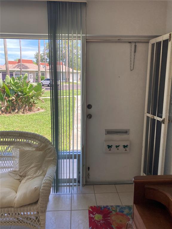 A white front door with a mail slot opens to a view of a grassy courtyard — 4313 TAHITIAN GARDENS CIRCLE CIRCLE UNIT B, HOLIDAY, FL