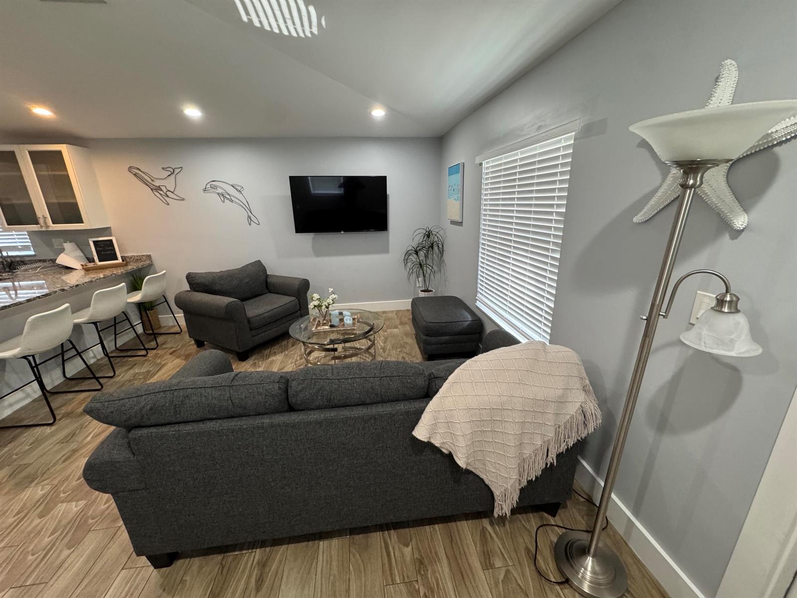 A living room features a grey sofa, armchair, television, and a floor lamp — 601 N E Street, FL 33460, FL