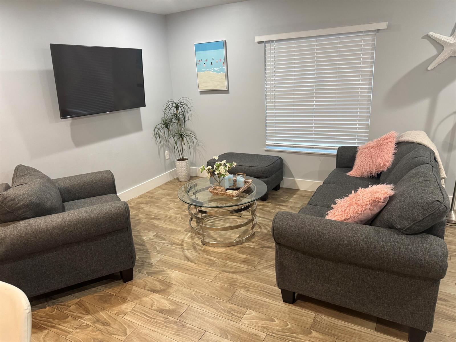 A living room features gray furniture, a glass coffee table, and wood-look tile flooring — 601 N E Street, FL 33460, FL
