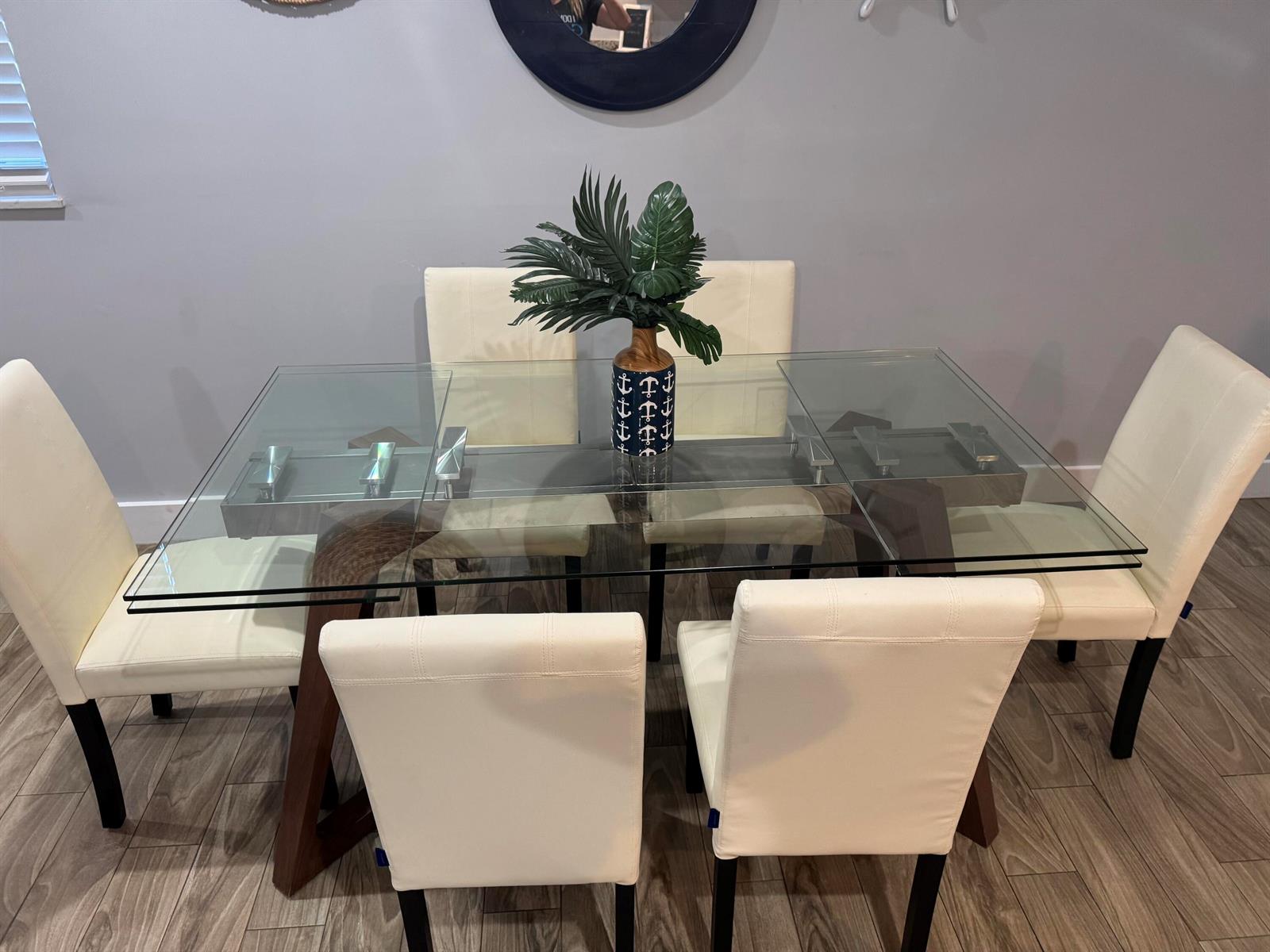 A dining room features a glass-topped table with a wooden base and six white chairs — 601 N E Street, FL 33460, FL