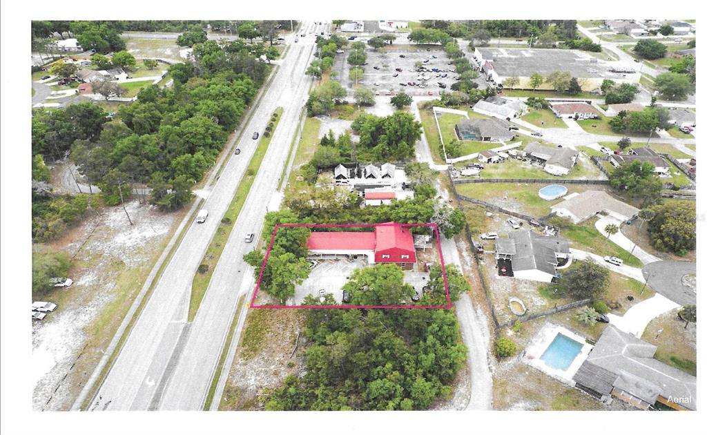 A brick building exterior features a covered walkway, a glass door, and a storefront sign — 2820 HOWLAND BOULEVARD, DELTONA, FL