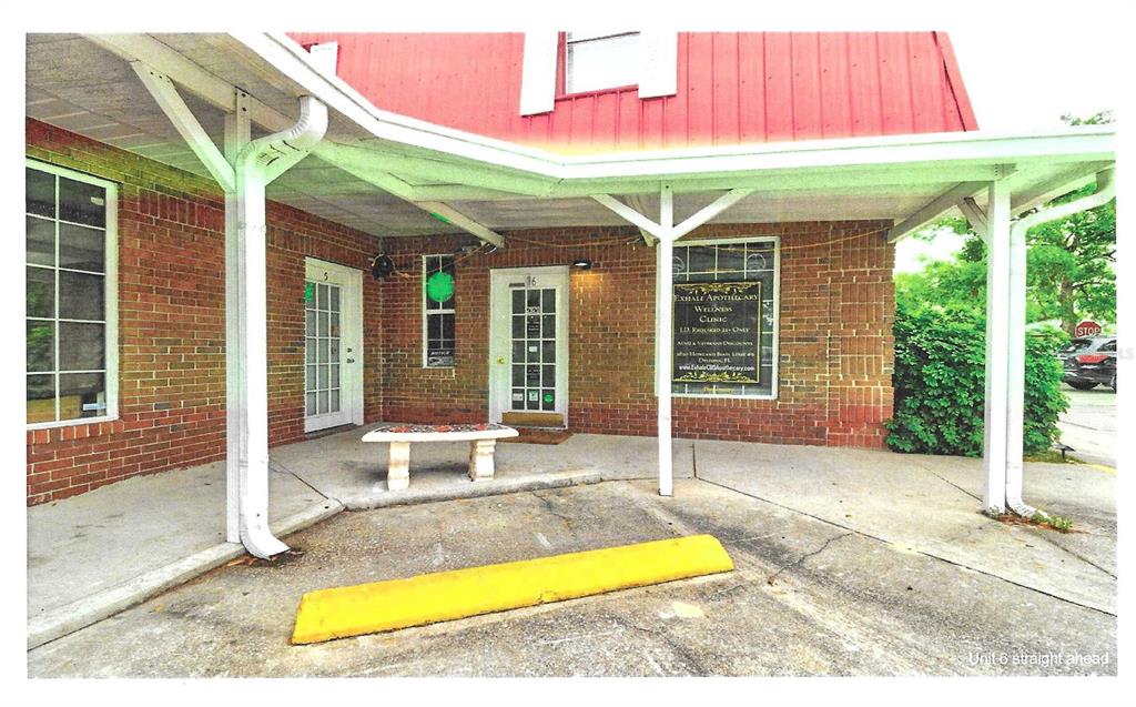 An elevated view shows a paved parking area behind a building with a red roof — 2820 HOWLAND BOULEVARD, DELTONA, FL