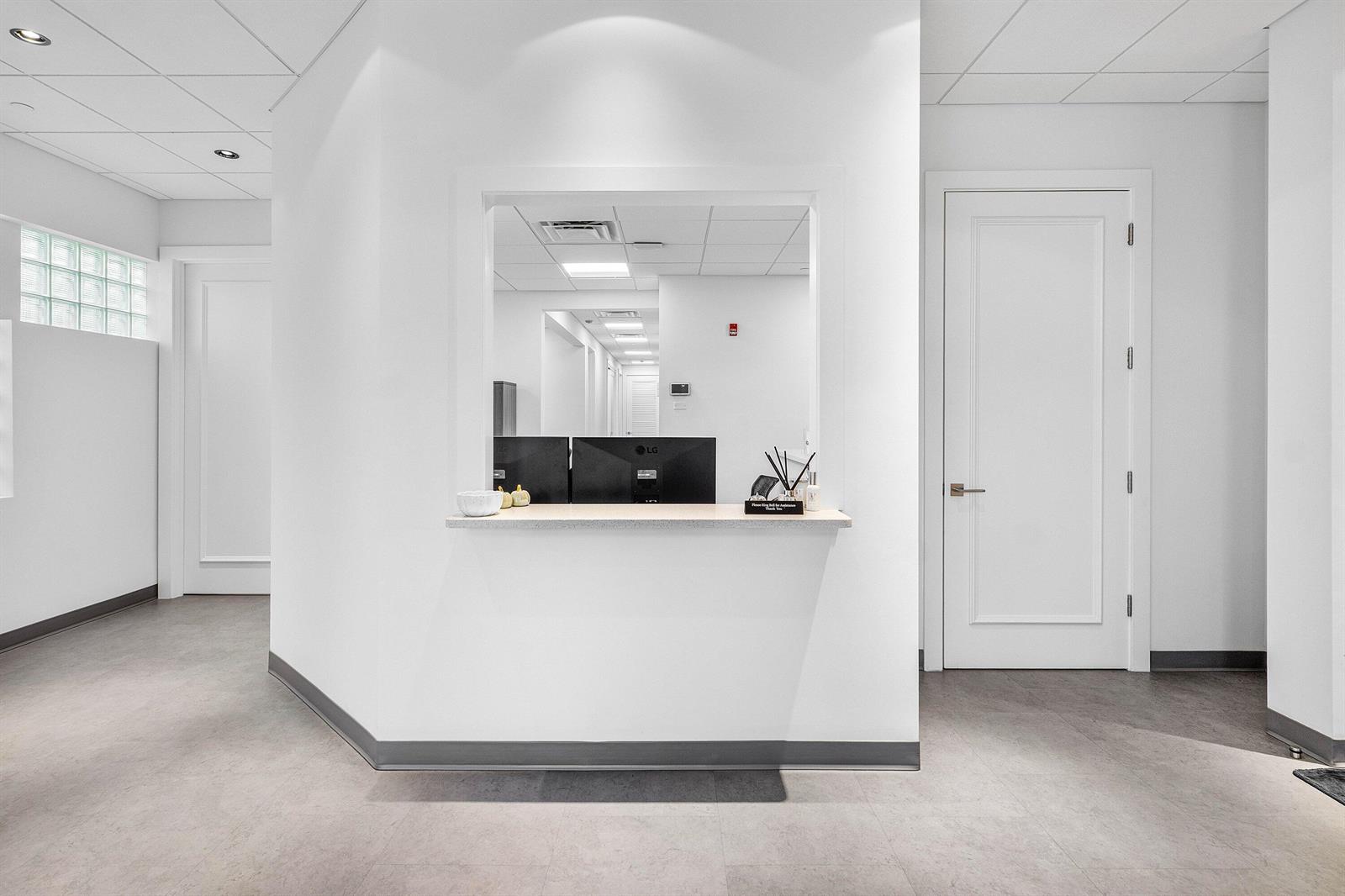 A bright reception area features a service window, white walls, and gray tile flooring — 226 Palm Court, Delray Beach FL 33444, DELRAY BEACH, FL