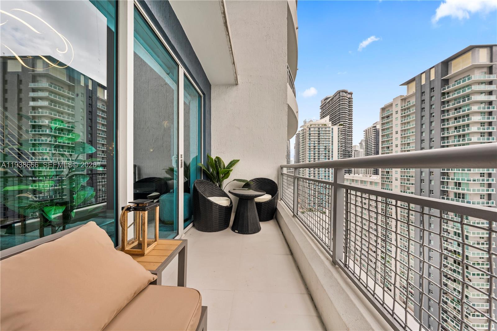 A high-rise balcony features a small seating area with two chairs and a table — 60 SW 13th St # 2422, Miami FL 33130, MIAMI, FL