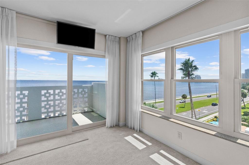 A carpeted room features floor-to-ceiling windows and a sliding glass door overlooking the ocean — 2401 BAYSHORE BOULEVARD UNIT 410 & 510, TAMPA, FL