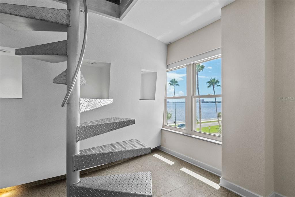 A room with a metal spiral staircase, tiled floors, and a window overlooking the water — 2401 BAYSHORE BOULEVARD UNIT 410 & 510, TAMPA, FL