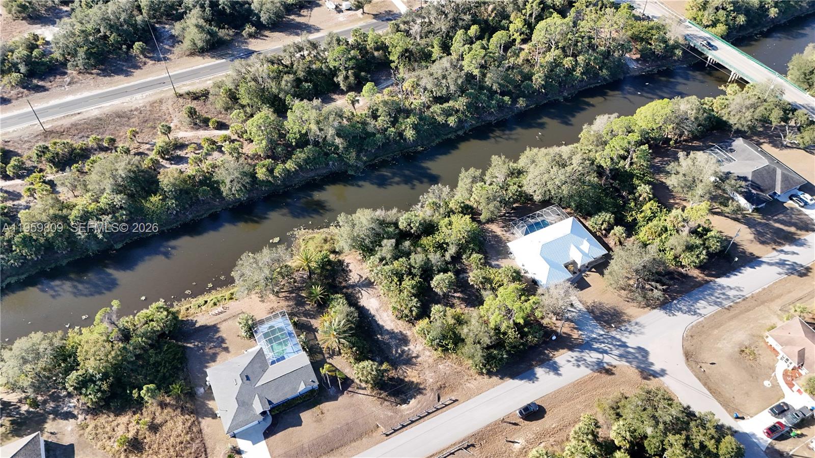 An aerial view shows two houses with screened pools situated along a winding river — 0 Adelaide Ave, North Port FL 34288, NORTH PORT, FL