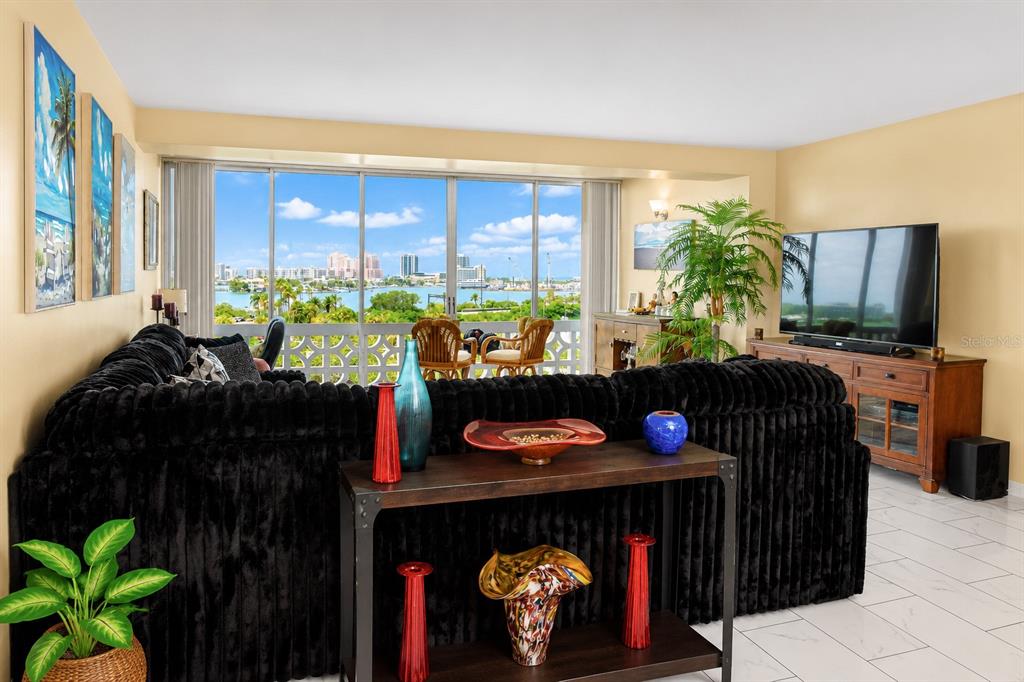 A living room with a black sectional sofa, a console table, and a waterfront view — 31 ISLAND WAY UNIT 505, CLEARWATER BEACH, FL