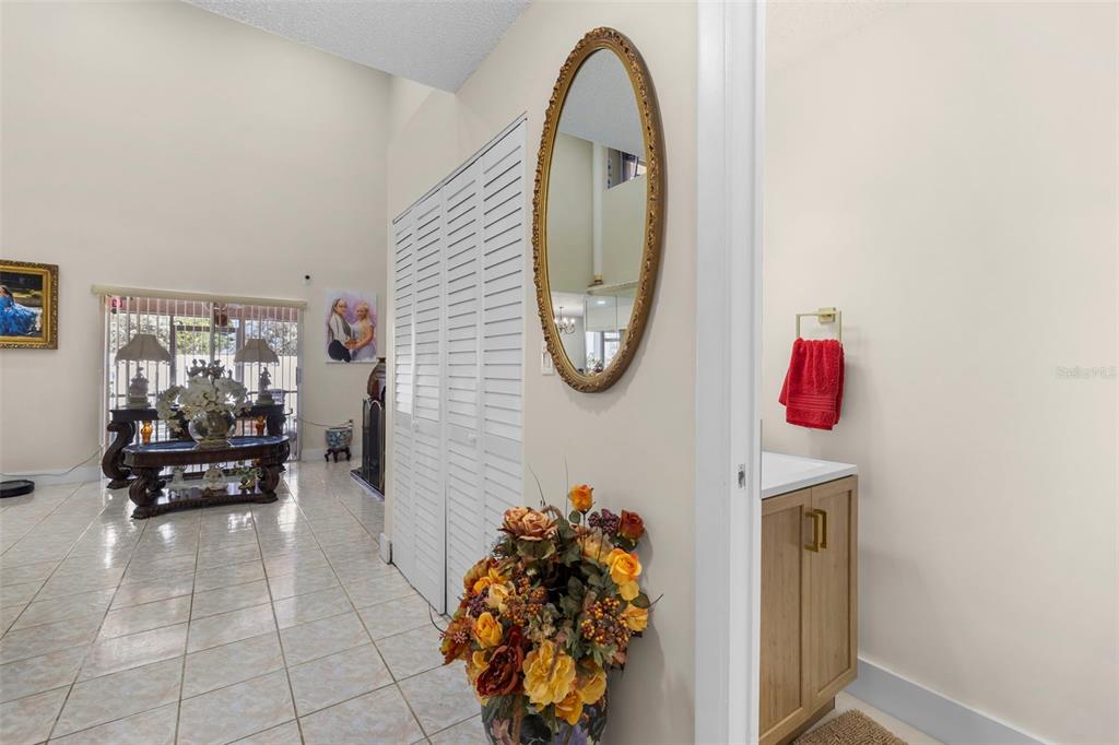 A tiled hallway leads to a living area with a mirror and a small vanity — 11951 SW 208TH TERRACE, MIAMI, FL