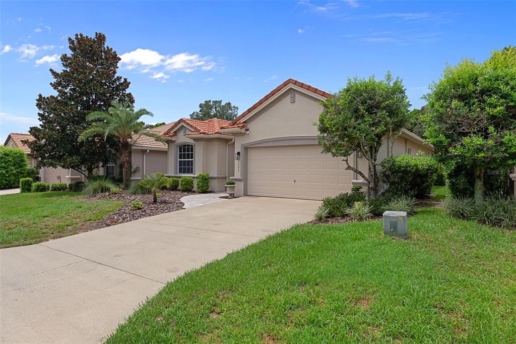 A single-story house with a beige stucco exterior, a tile roof, and a two-car garage — 1283 W DIAMOND SHORE LOOP, HERNANDO, FL