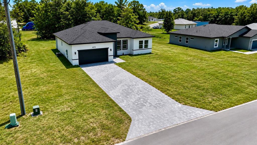 An aerial view shows a single-story house with a paved driveway and a dark roof — 15775 SW 59TH AVENUE ROAD, OCALA, FL