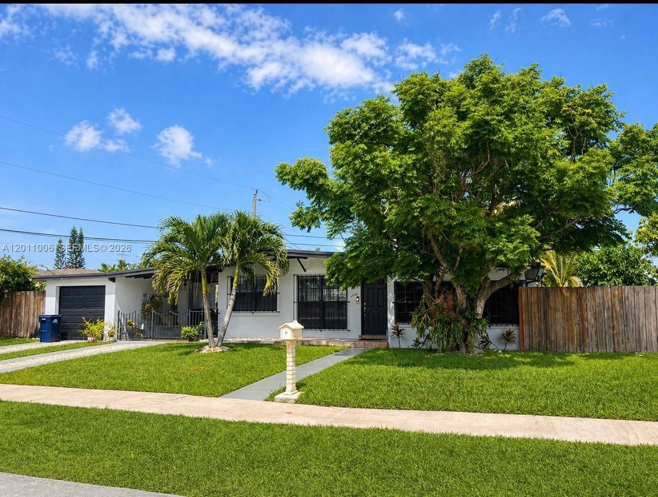 A single-story white house with a dark garage, a large tree, and a wooden fence — 4825 SW 111th Ave, Miami FL 33165, MIAMI, FL