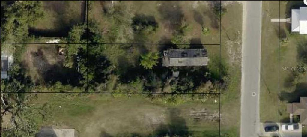 An aerial view shows a rectangular house on a wooded lot next to a road — 509 N JAMES AVENUE, PANAMA CITY, FL