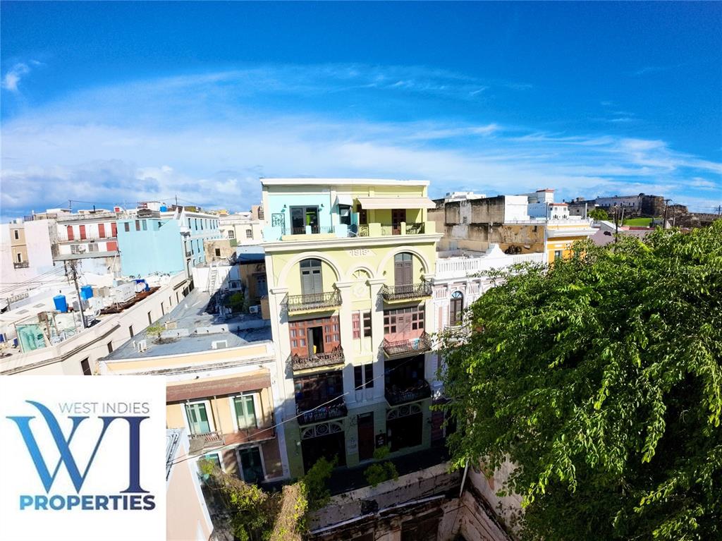An aerial view of a multi-story yellow building with balconies in a dense urban area — 351 FORTALEZA UNIT 7, SAN JUAN, PR
