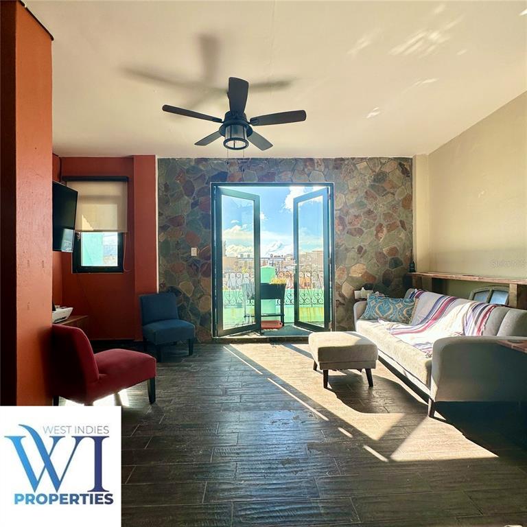 A living room features a stone accent wall, tile flooring, and French doors leading outside — 351 FORTALEZA UNIT 7, SAN JUAN, PR
