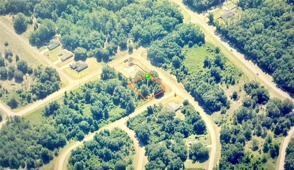 An aerial view shows a vacant, wooded residential lot outlined in red with a green marker — 689 E HOPE PLACE, CITRUS SPRINGS, FL