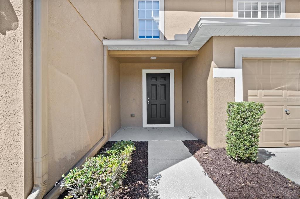 A grassy lawn slopes down to a small pond bordered by a line of trees — 4535 WINDING RIVER WAY, LAND O LAKES, FL