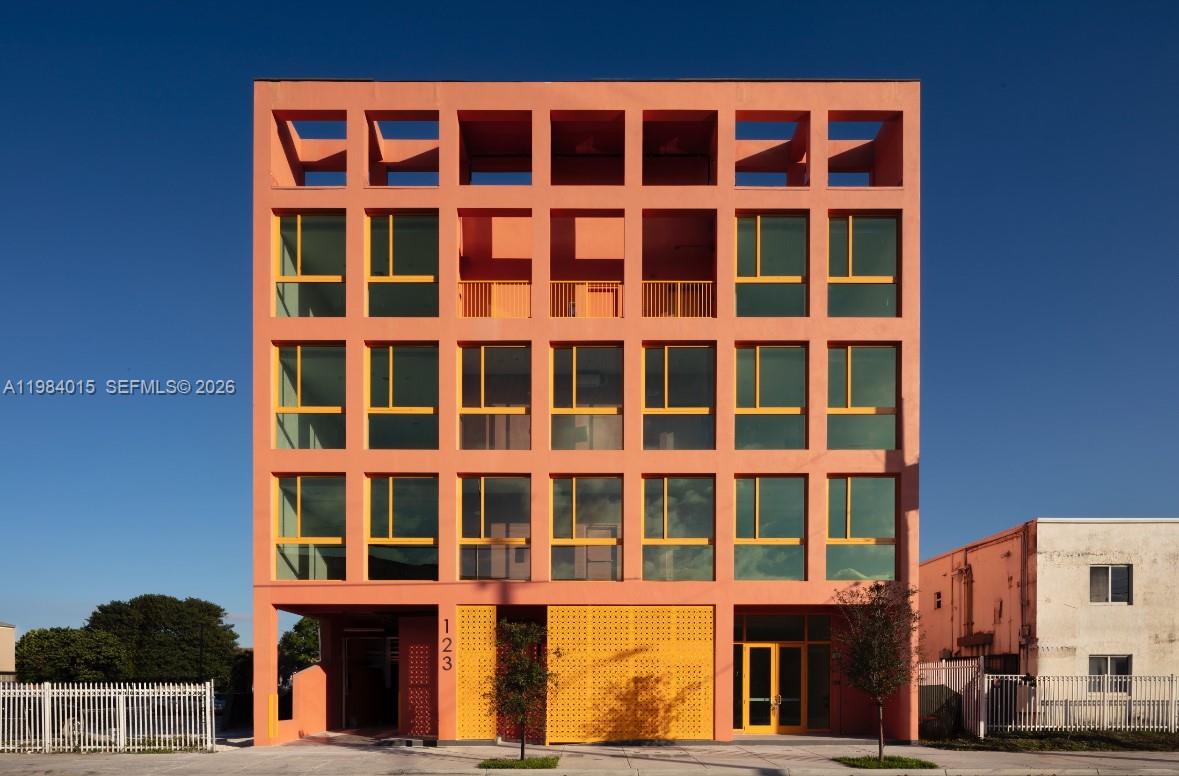 A modern, peach-colored five-story building features a grid-like facade with large windows and ground-level entrances — 123 NW 14th St # 200, Miami FL 33136, MIAMI, FL