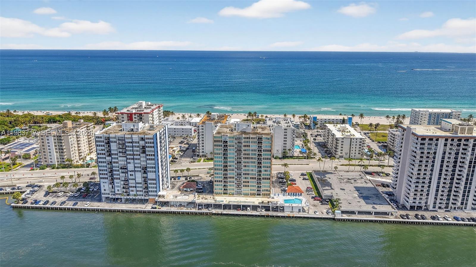 An aerial view shows several high-rise residential buildings situated between a bay and the ocean — 1410 S Ocean Dr # 601, Hollywood FL 33019, HOLLYWOOD, FL
