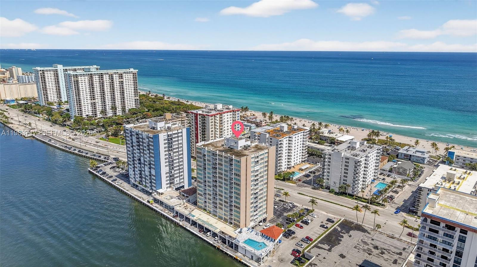 An aerial view shows several high-rise residential buildings situated between a bay and the ocean — 1410 S Ocean Dr # 601, Hollywood FL 33019, HOLLYWOOD, FL
