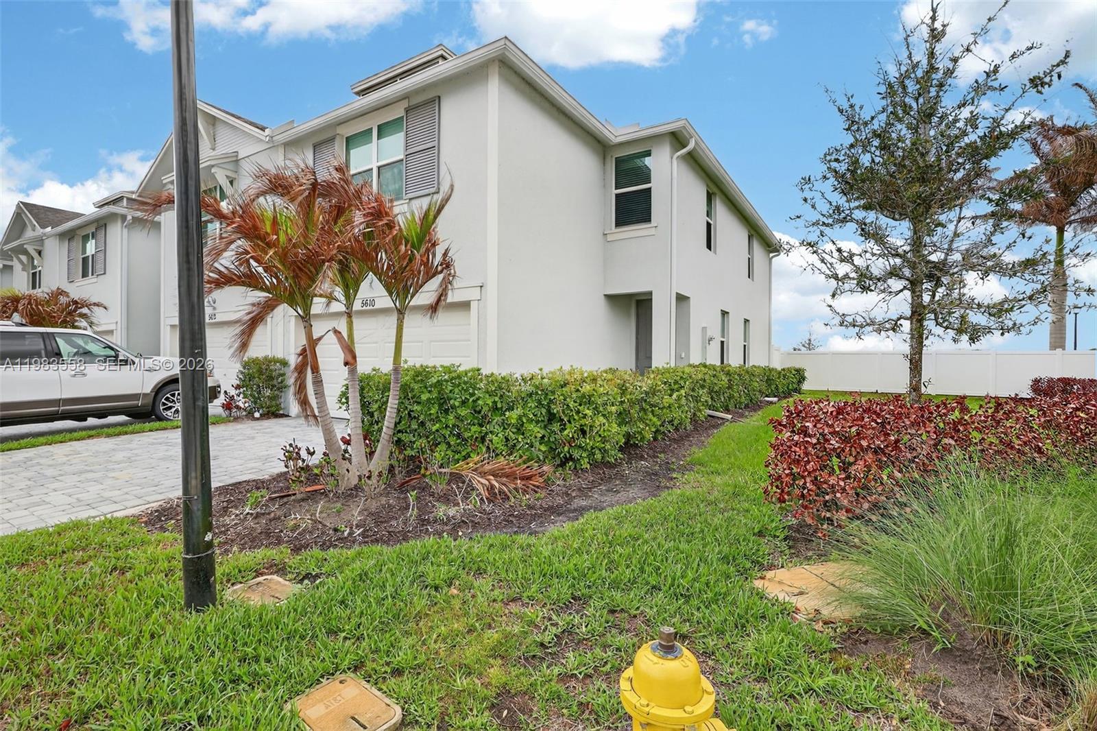 A two-story townhouse with a paved driveway, landscaping, and a yellow fire hydrant — 5610 SE Edgewater Cir, Stuart FL 34997, STUART, FL