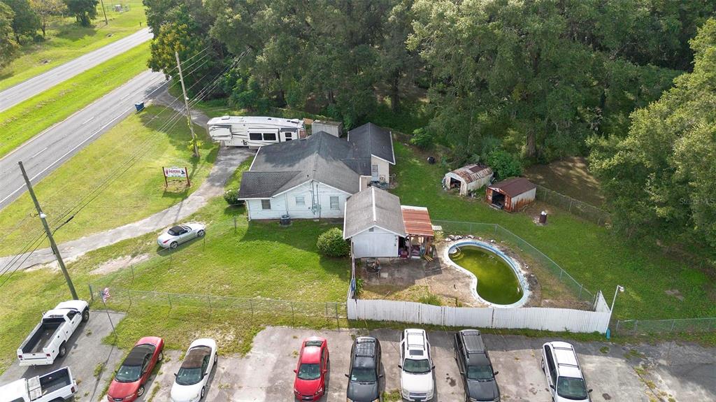 An aerial view shows a house with a swimming pool and a parking lot — 2480 N WOODLAND BOULEVARD, DELAND, FL