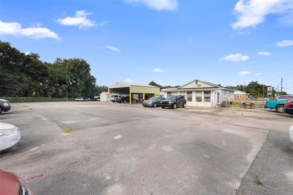 An exterior view of a commercial property with a parking lot and a service bay — 2480 N WOODLAND BOULEVARD, DELAND, FL