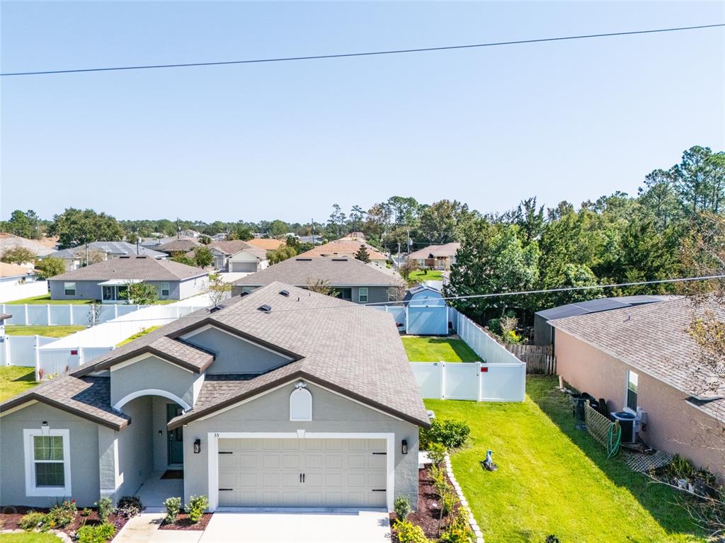 An aerial view shows a suburban house with a gray roof and a fenced backyard — 35 ROLLINS LANE, PALM COAST, FL