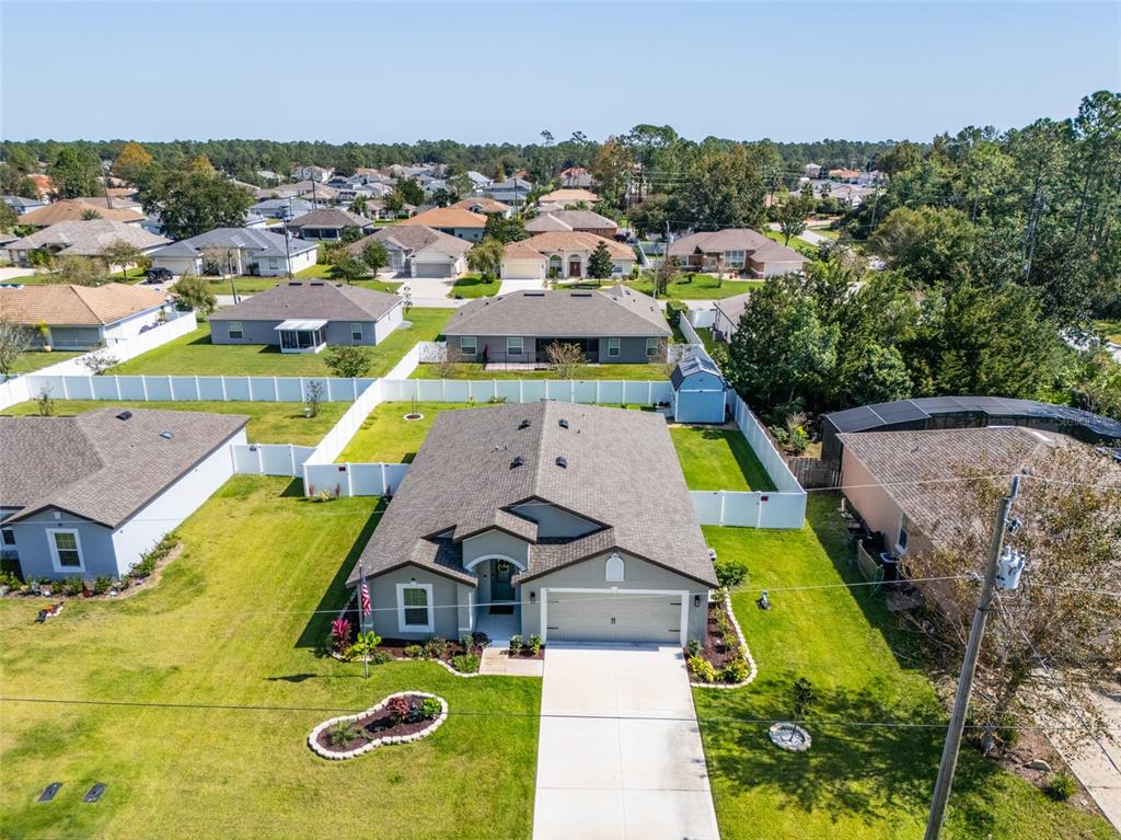 An aerial view shows a suburban single-story house with a garage and fenced backyard — 35 ROLLINS LANE, PALM COAST, FL