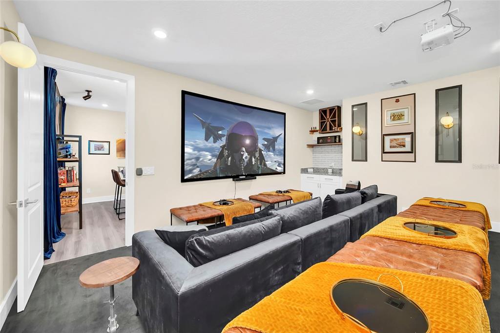 A home theater room features a large projection screen, tiered seating, and a wet bar — 1213 RADIANT STREET, REUNION, FL