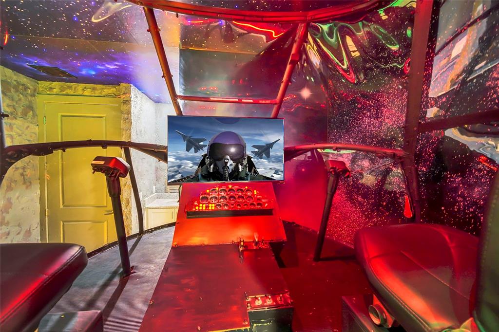 A themed home theater room features a flight simulator cockpit setup with a central monitor — 1213 RADIANT STREET, REUNION, FL