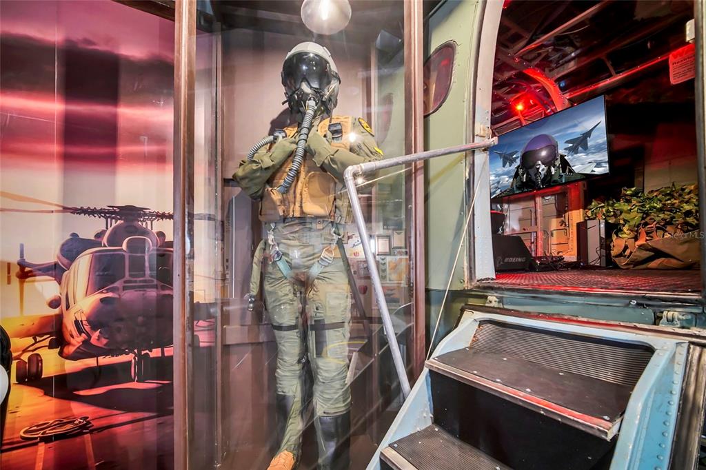 A display case features a pilot mannequin next to a staircase leading into a room — 1213 RADIANT STREET, REUNION, FL