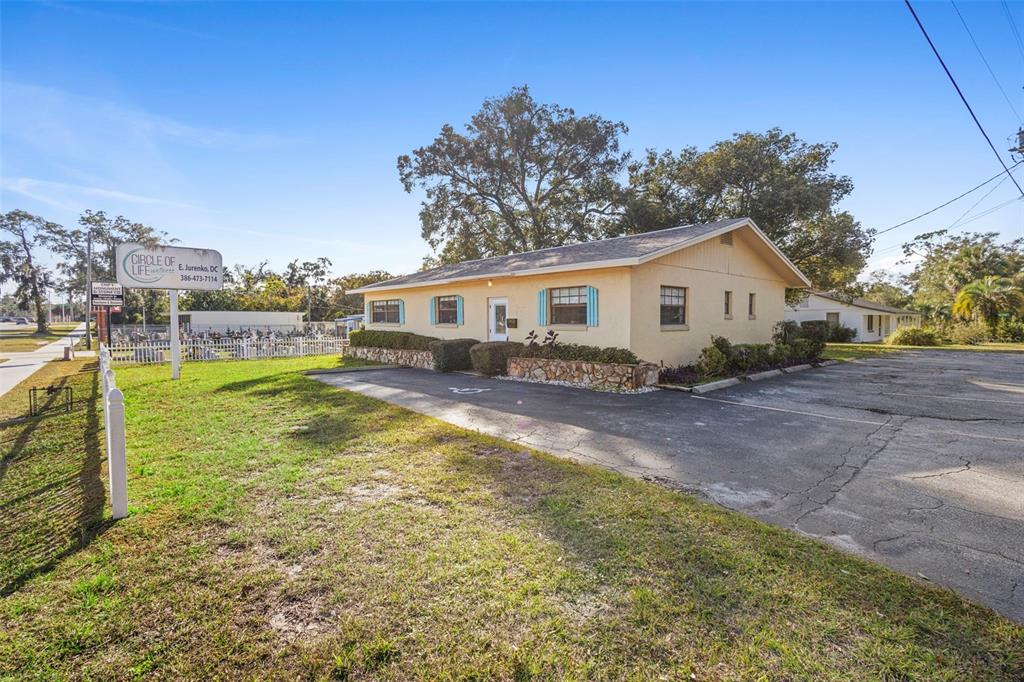 A single-story yellow building with a stone-accented base and a paved parking lot — 1995 N VOLUSIA AVENUE, ORANGE CITY, FL