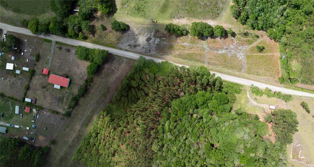An aerial view shows a rural property with a house, outbuildings, forest, and a road — NW 185TH STREET, STARKE, FL
