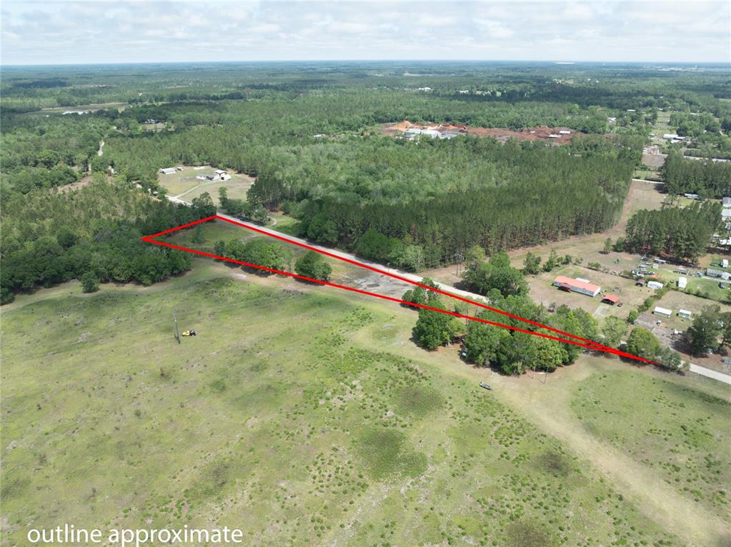 An aerial view shows a grassy field with a red outline marking a property boundary — NW 185TH STREET, STARKE, FL