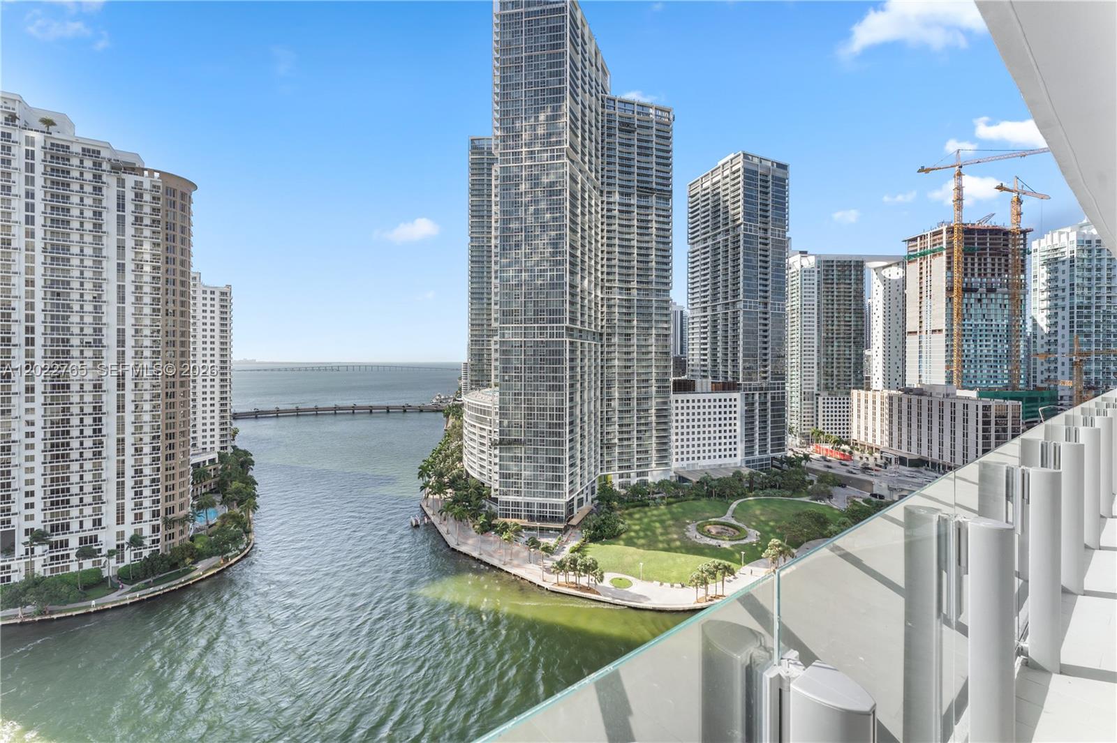 A high-angle view from a balcony overlooking a waterfront park and city skyscrapers — 300 Biscayne Blvd Way # 1802, Miami FL 33131, MIAMI, FL