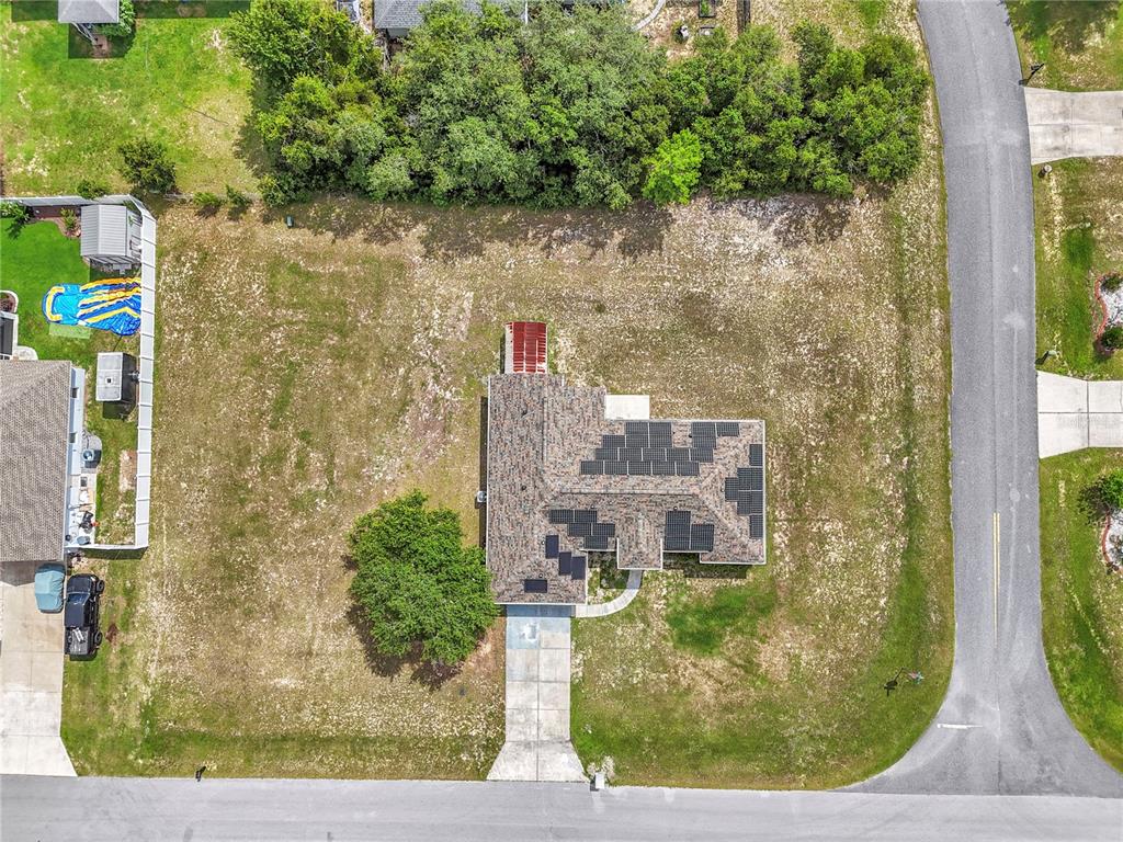 An aerial view shows a house with solar panels on a large, grassy lot — 14147 SW 33 CT ROAD, OCALA, FL