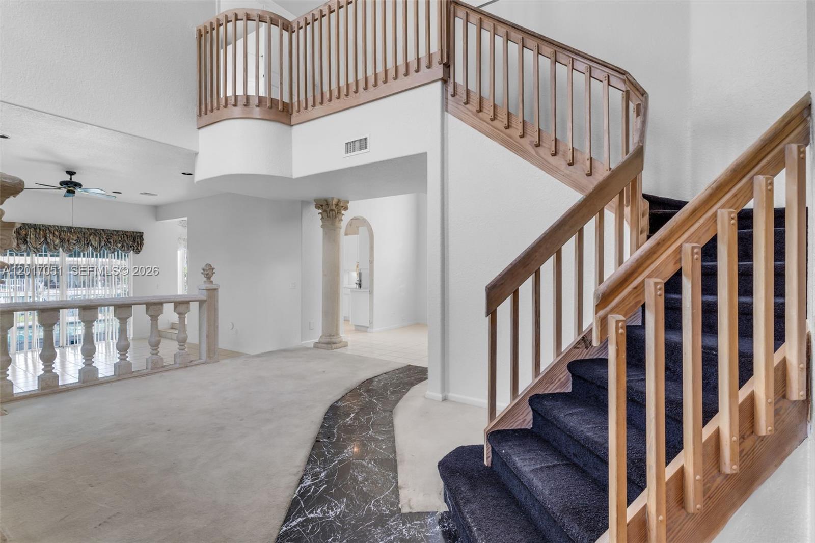 An interior view shows a carpeted staircase with wooden railings and a marble floor accent — 14876 SW 132nd Ave, Miami FL 33186, MIAMI, FL