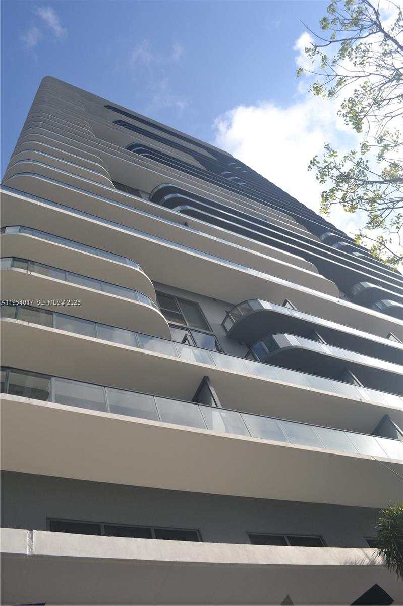 A low-angle view shows the exterior facade of a modern high-rise residential building — 121 NE 34th St # 2110, Miami FL 33137, MIAMI, FL