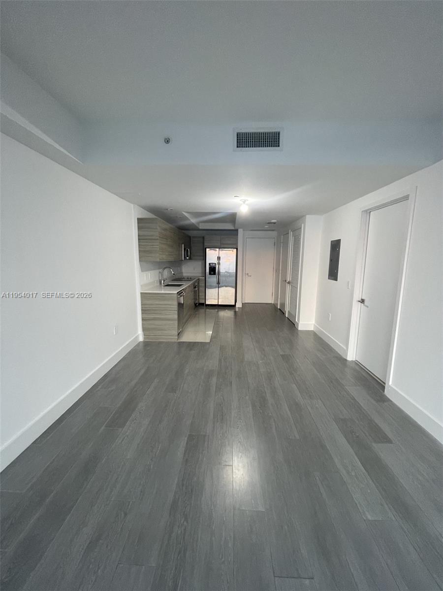 This interior view shows a modern kitchen with gray wood-look flooring and white walls — 121 NE 34th St # 2110, Miami FL 33137, MIAMI, FL