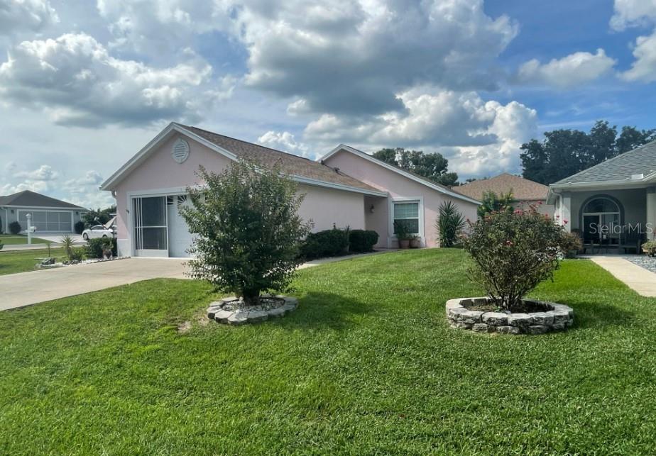 A light pink, single-story house with a garage and two small trees in the yard — 5399 NW 18TH STREET, OCALA, FL